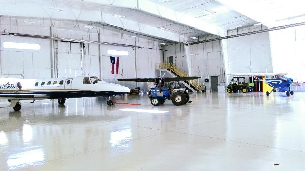 Photograph of the Interior of the Airport Hangar with a Small Plane and Helicopter
