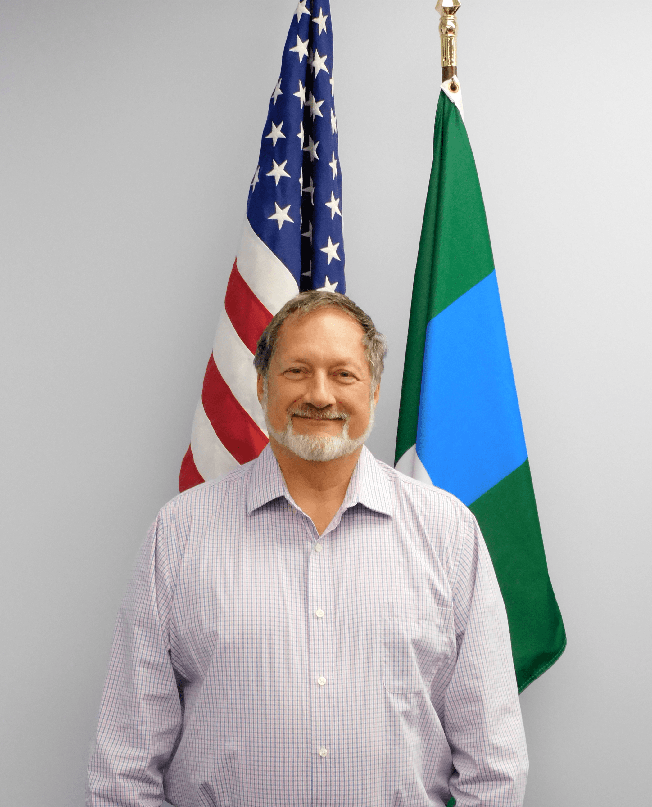 Photograph of Councilmember Gregg Obren in the Council Chambers in front of US and State Flag